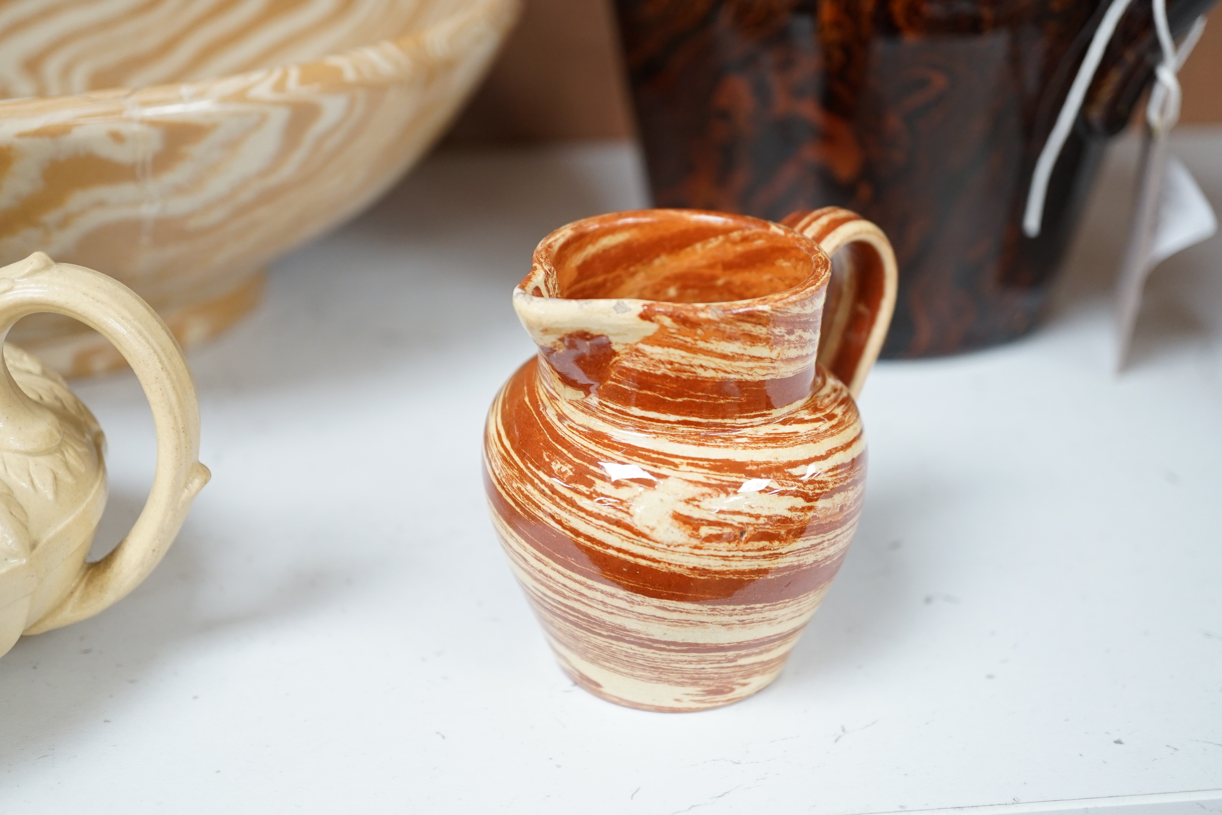 A Victorian solid agate ware pottery jug, a similar bowl and pair of miniature jugs, an unusual Doulton Lambeth stoneware jug and a small relief-moulded teapot, Doulton jug, 19cms high